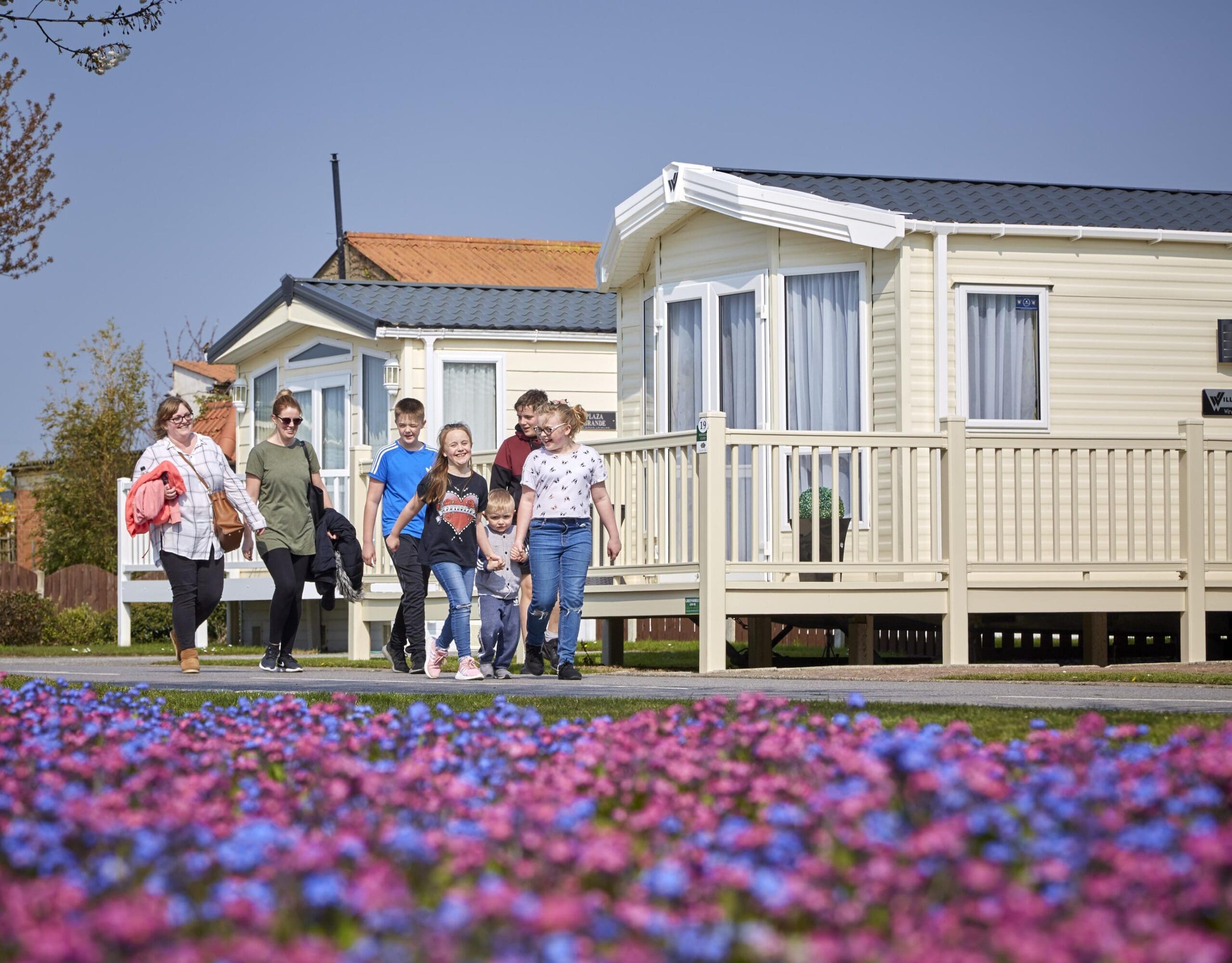 family with smiles walking infront of caravans at patrington haven leisure park