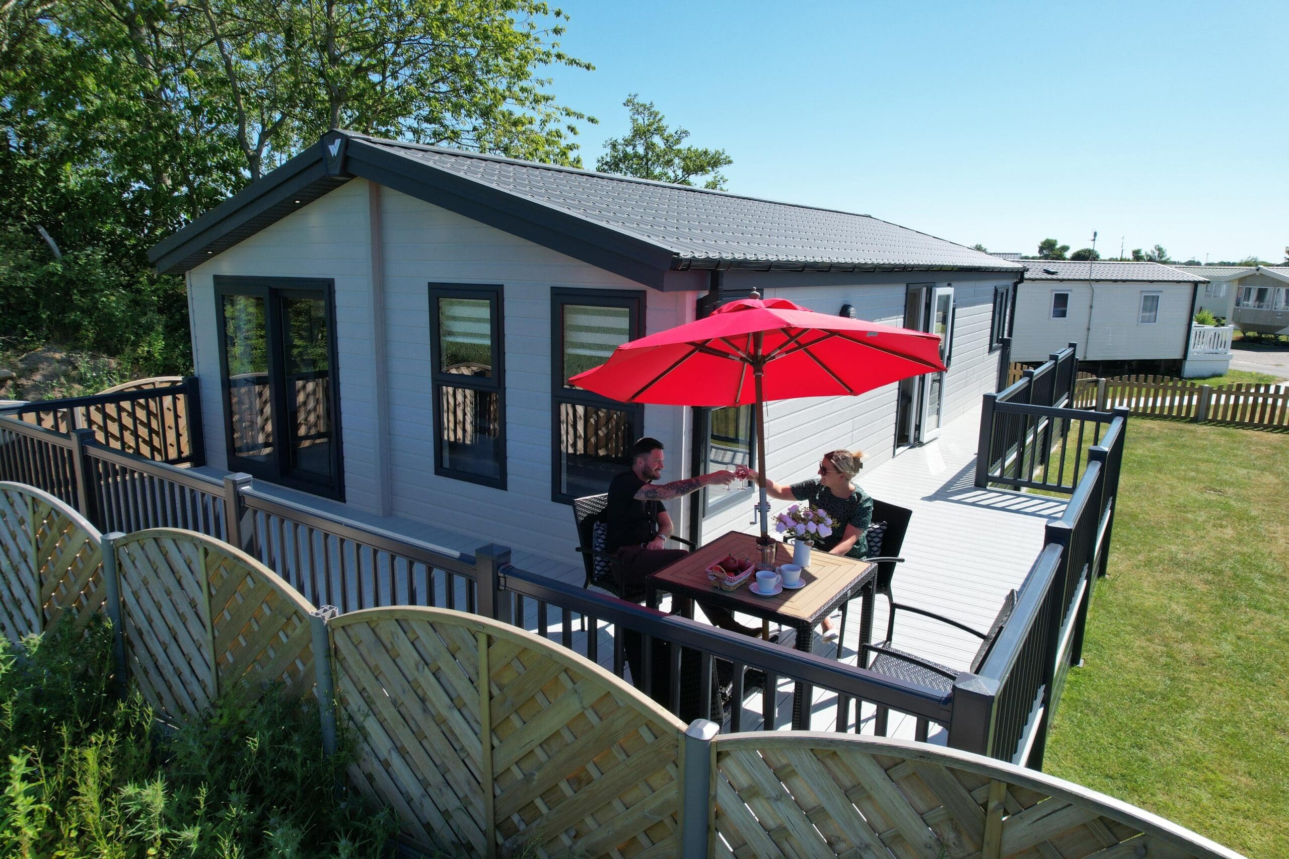 a couple sat on the decking of their holiday home