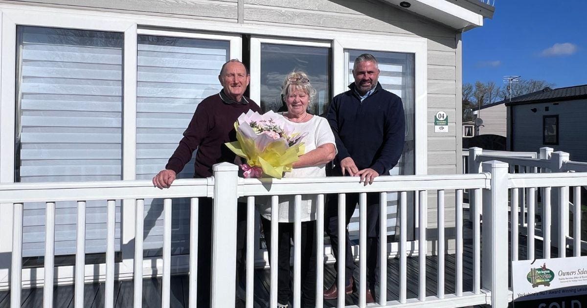 holiday home owners infront of their caravan