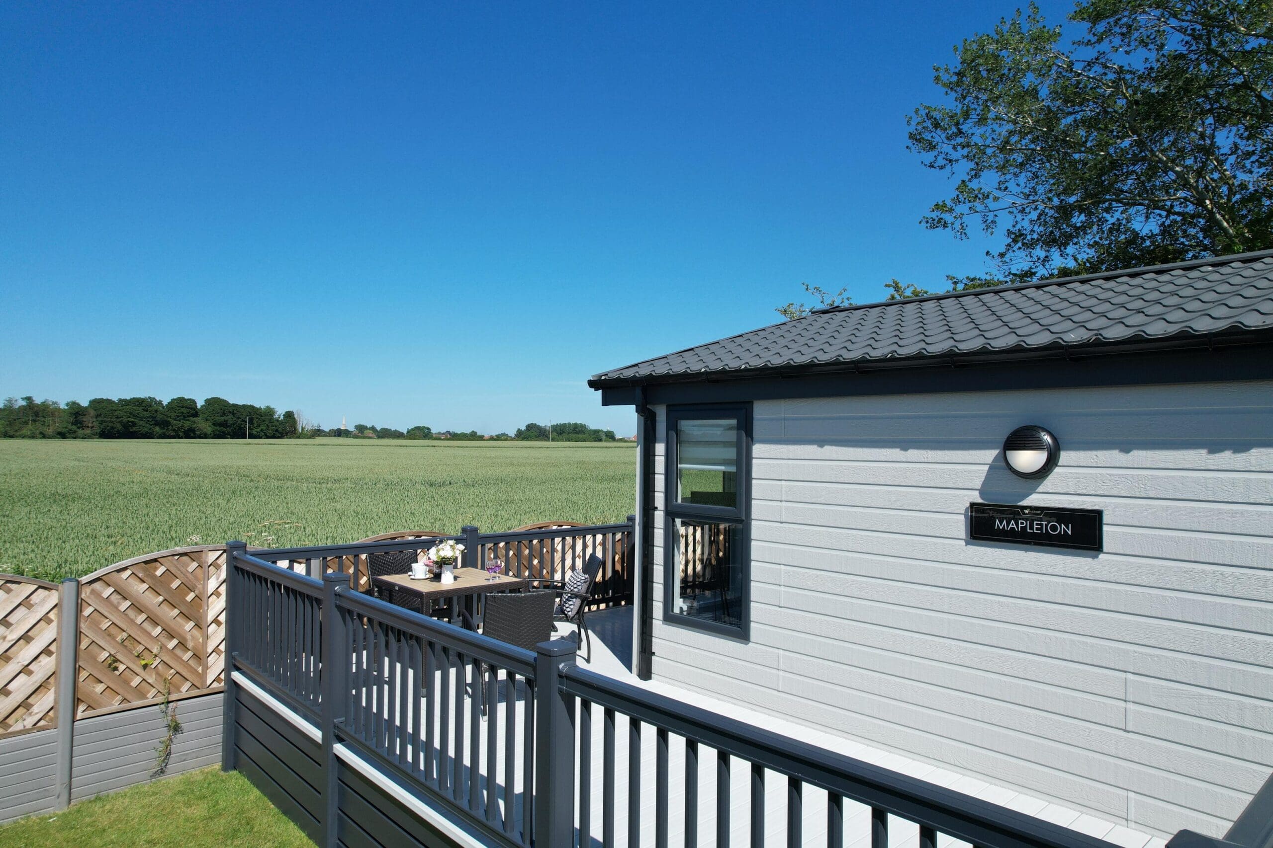The image showcases a scenic view of the East Yorkshire countryside, from a private garden plot at Patrington Haven Leisure Park